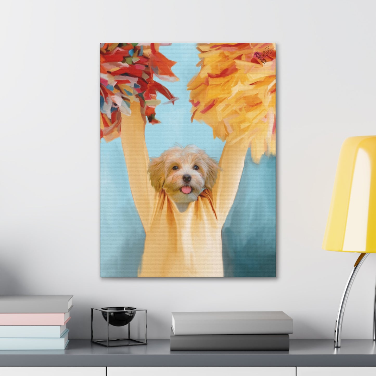 Canvas print of a dog in a yellow shirt with pom-poms on a wall above a desk.