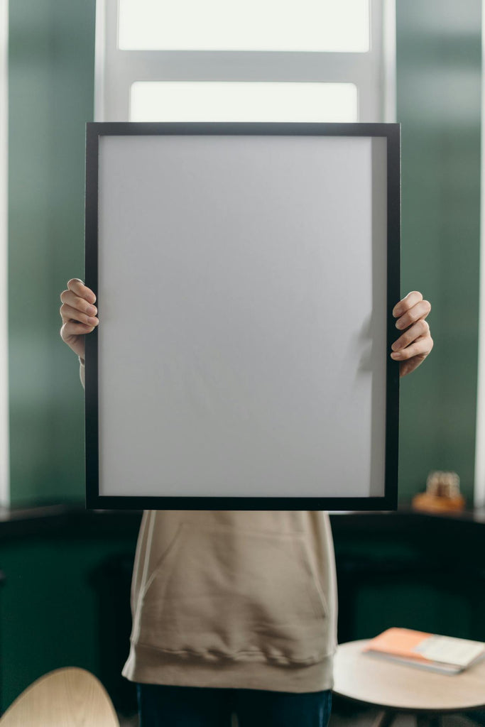 Person holding a framed canvas