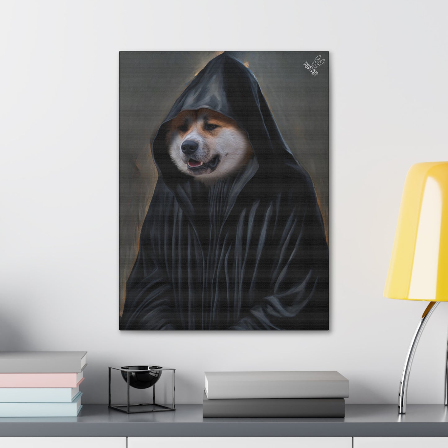 Framed artwork of a dog in a hood on a wall above a desk with books and a lamp.